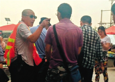 地铁天通苑北站外的广场上，一名套着“Police”(警察)字样背心的人要求摆摊的记者离开，但没驱赶其他摊贩。