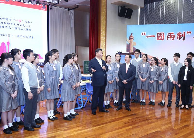2019年12月19日,国家主席习近平在澳门特别行政区行政长官崔世安陪同下,来到位于澳门黑沙环的政府综合服务中心和濠江中学附属英才学校,同澳门市民和师生亲切交流。在濠江中学附属英才学校观摩以“‘一国两制’与澳门”为题的中国历史公开课后,习近平走到学生中间即席发表重要讲话。新华社记者 鞠鹏 摄