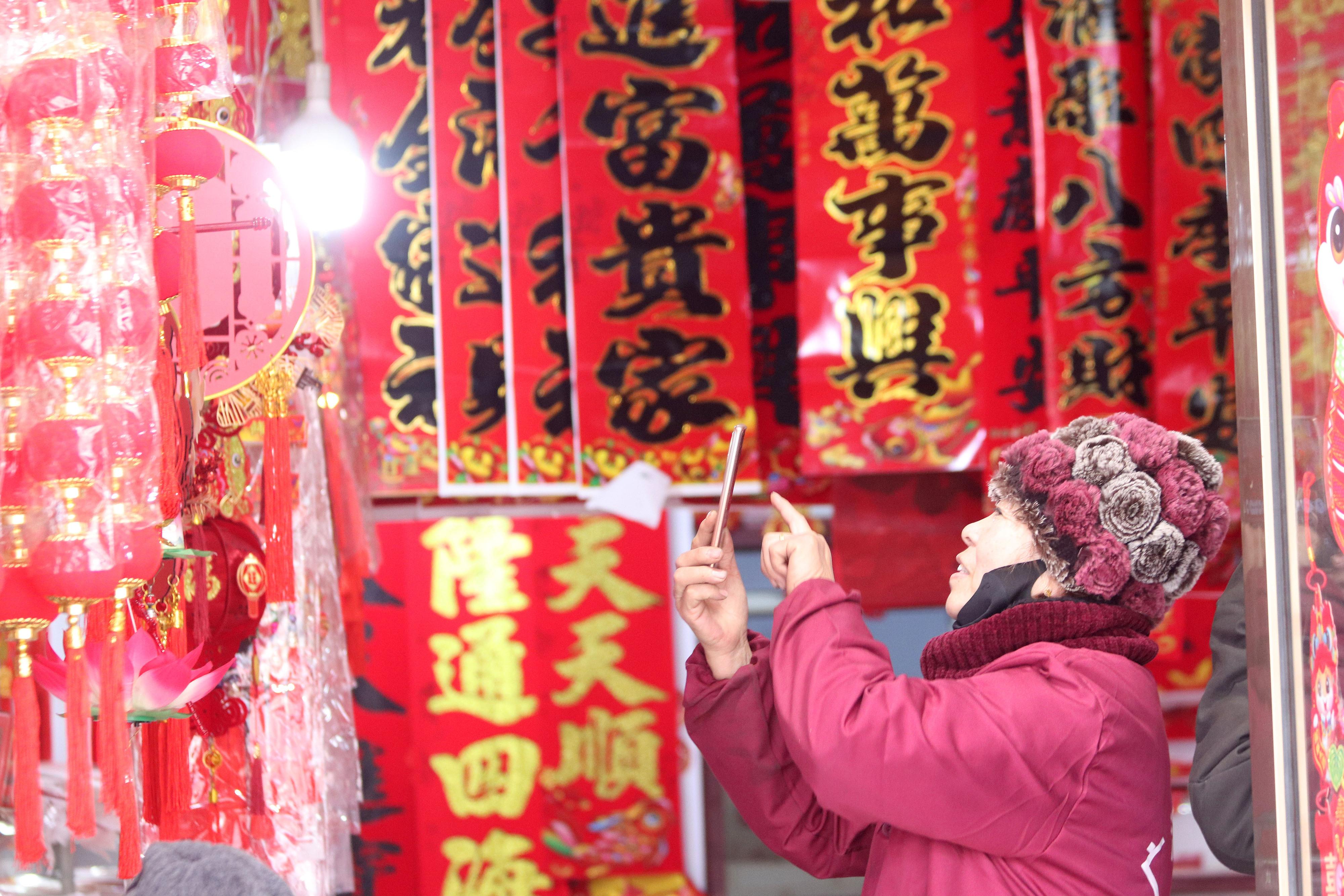 2025年1月5日,在山东省高密市夏庄镇东李家村,商户使用手机推销新春饰品。